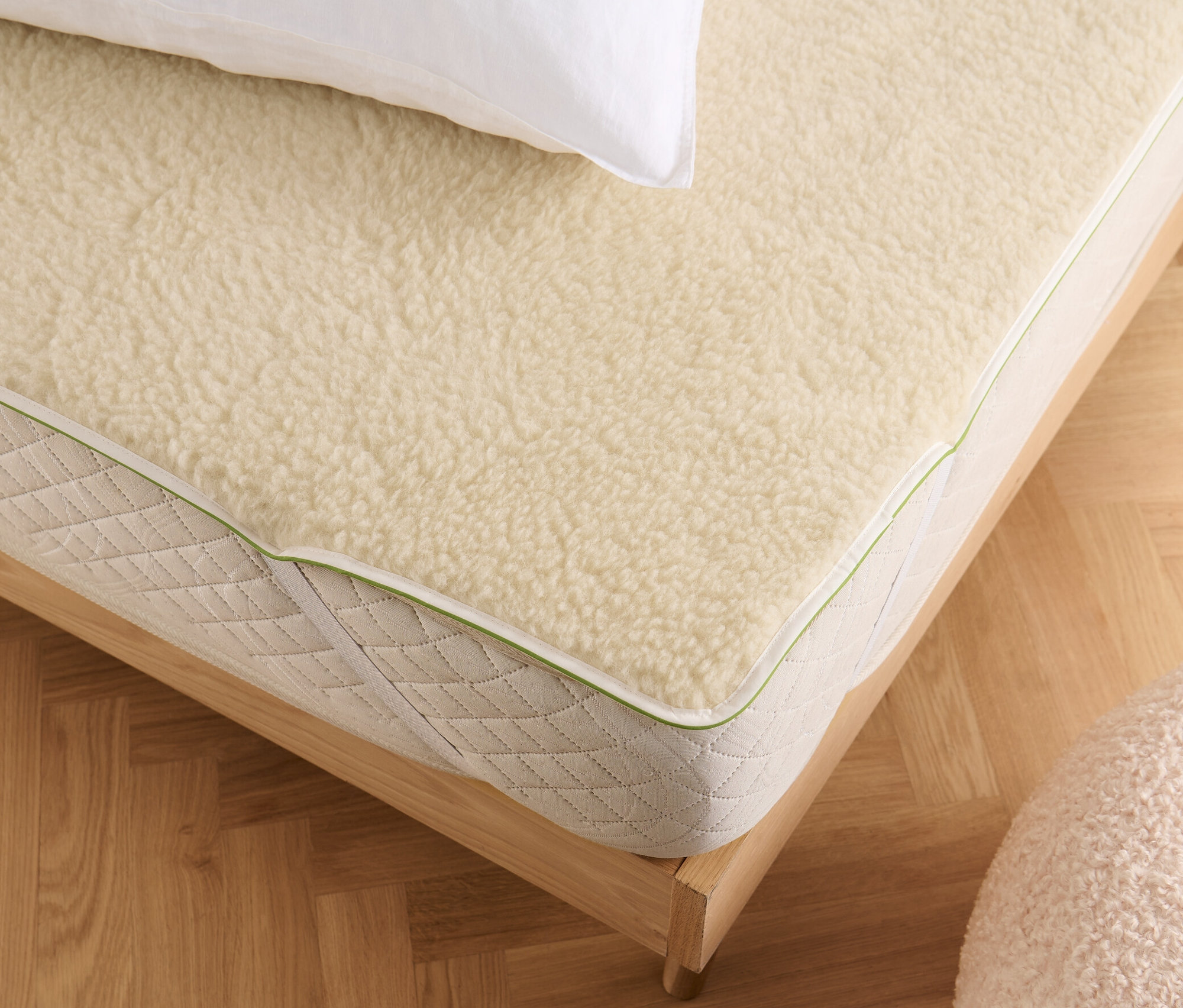 Weißes Kissen liegt auf irisette® greenline Matratzenauflage.