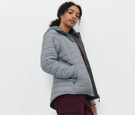 Frau posiert in wasserdichter Wende-Steppjacke in Grau.