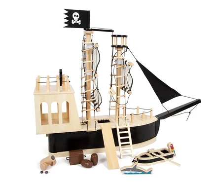 Ein hölzernes Piratenschiff "small foot Piratenschiff" mit schwarzer Flagge mit Totenkopf, Leitern, Fässern, einem Boot und einem Hai auf weißem Hintergrund.