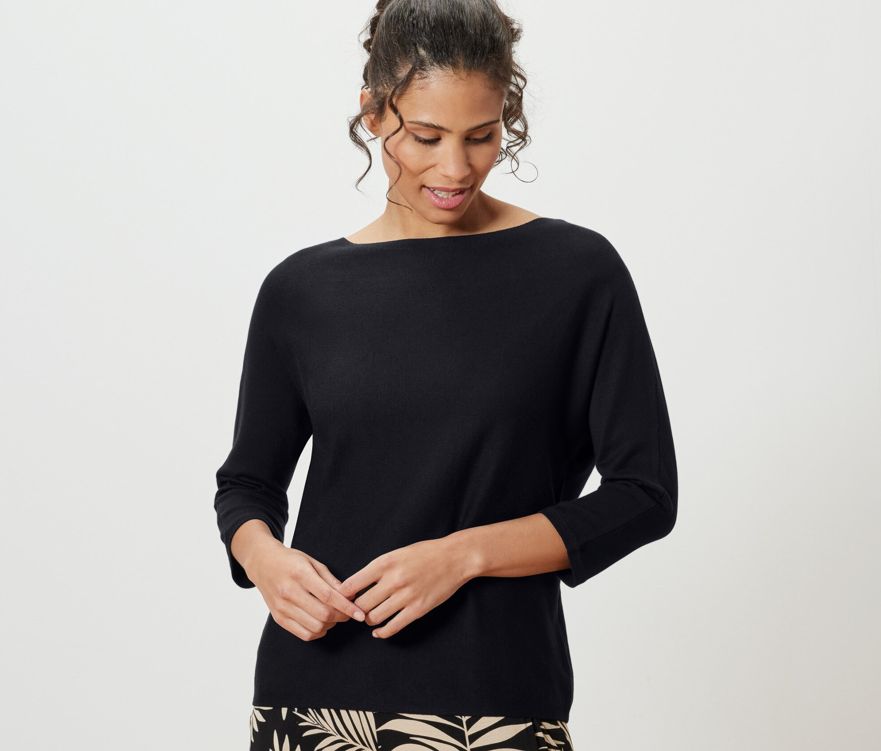 Frau trägt schwarzen Feinstrickpullover.