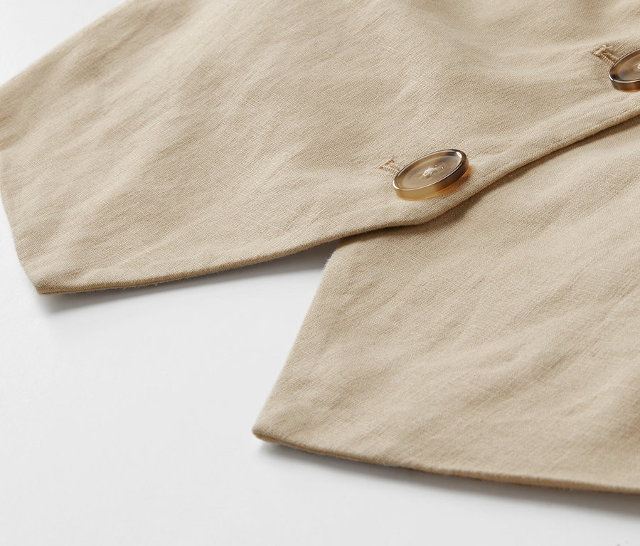 Detailaufnahme einer Leinen-Weste mit Knöpfen.
