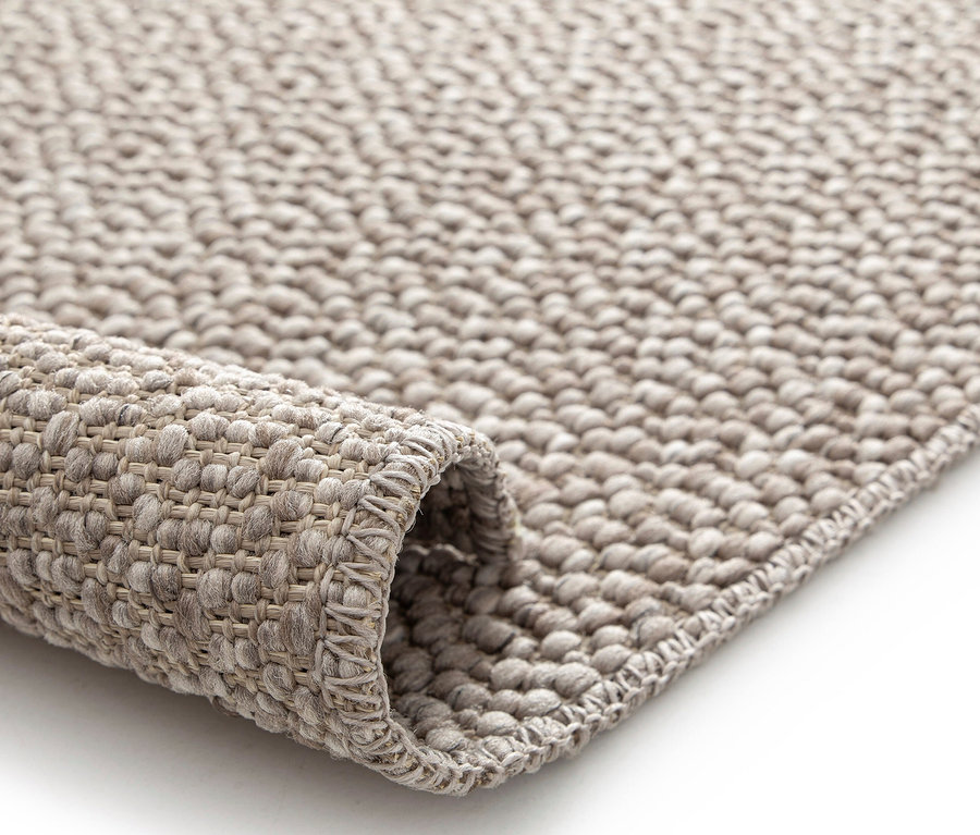 Detailansicht eines beigen Teppichs »Twine« mit sanftem Chevron-Muster.