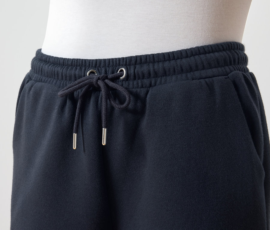 Detailaufnahme einer dunkelblauen Trainingshose mit Kordelzug in der Taille.