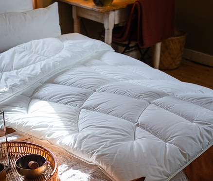 Nahaufnahme einer Paradies Ganzjahres-Faserdecke »ElbTraum« in Normalgröße auf einem Bett.