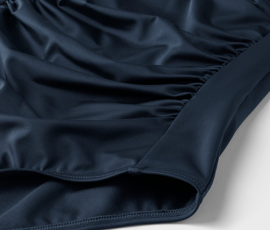Detailaufnahme eines marineblauen Stoffes mit Raffungen.