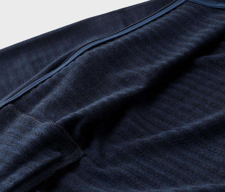 Nahaufnahme eines marineblauen Fleece-Oberteils mit Reißverschluss und Rippstruktur.