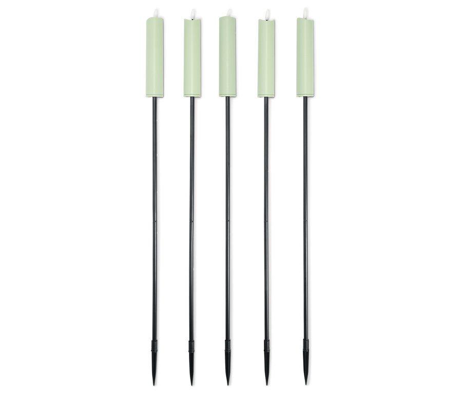 Fünf grüne Kerzen mit schwarzen Stäben stehen aufgereiht vor einem weißen Hintergrund.