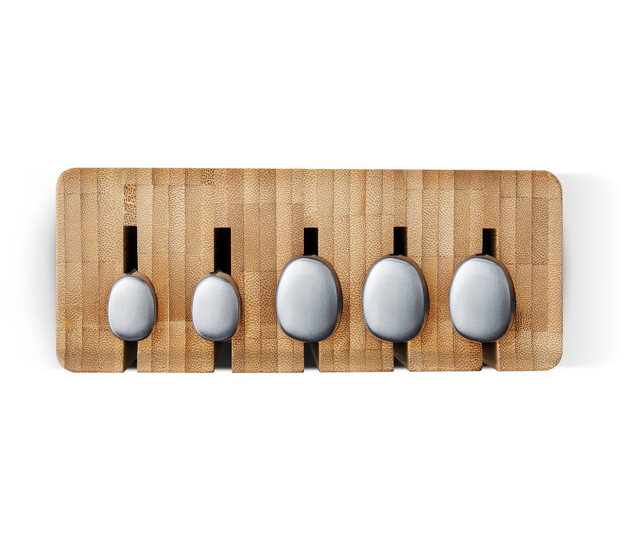 Fünf silberne Löffel unterschiedlicher Größe in einem Bambusständer.