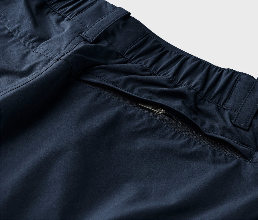 Nahaufnahme von marineblauen Hosen mit elastischem Bund und Reissverschlusstasche.