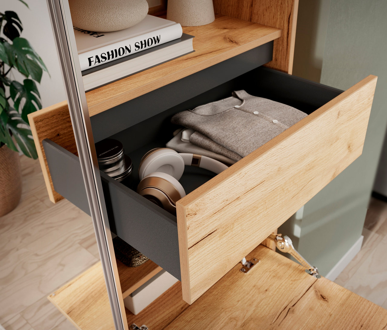 Offene Schublade der »Aledo« Kompaktgarderobe mit Kleidung und Kopfhörern. Darüber Buch und Deko.
