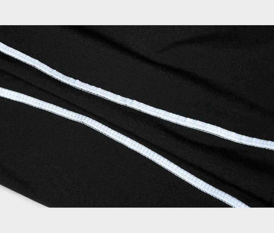 Nahaufnahme von schwarzem Stoff mit zwei parallelen, diagonal verlaufenden weißen Overlock-Nähten.