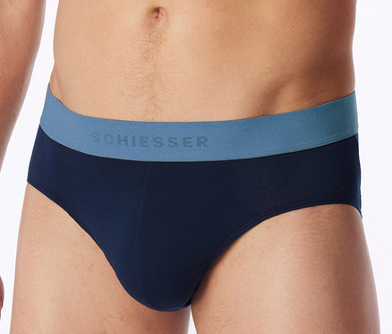 Mann trägt marineblaue Slips mit blauem Bund, auf dem "SCHIESSER" steht.