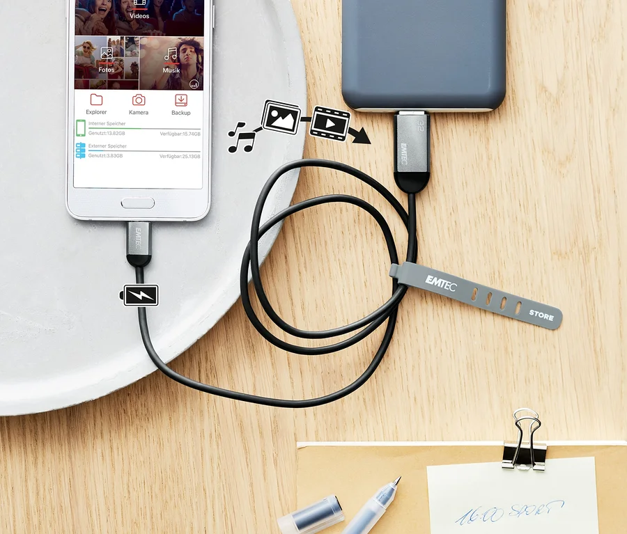 Telefon wird mit einem Backup- und Ladekabel von einer Powerbank auf einem Tablett geladen.