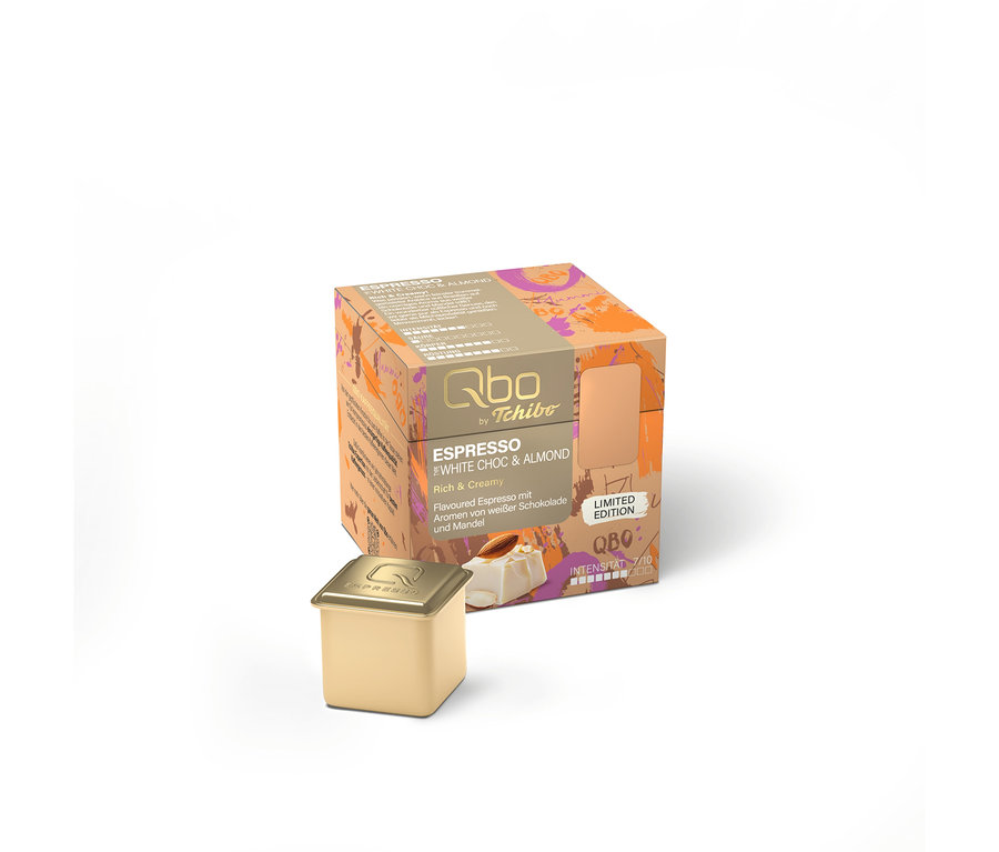 Eine goldene Qbo Kaffeekapsel steht vor einer orange-violetten Packung Qbo by Tchibo Espresso White Choc & Almond, Limited Edition, mit einer Intensität von 7/10.