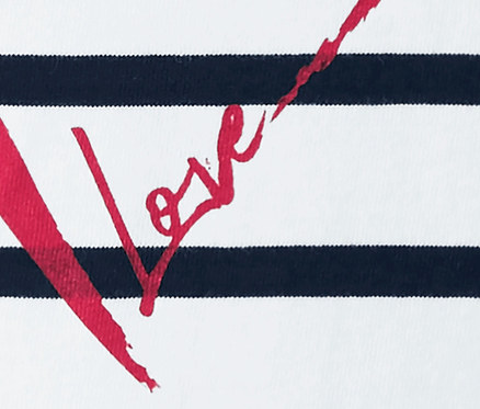 Detailansicht eines Streifenshirts mit rotem Love-Schriftzug.
