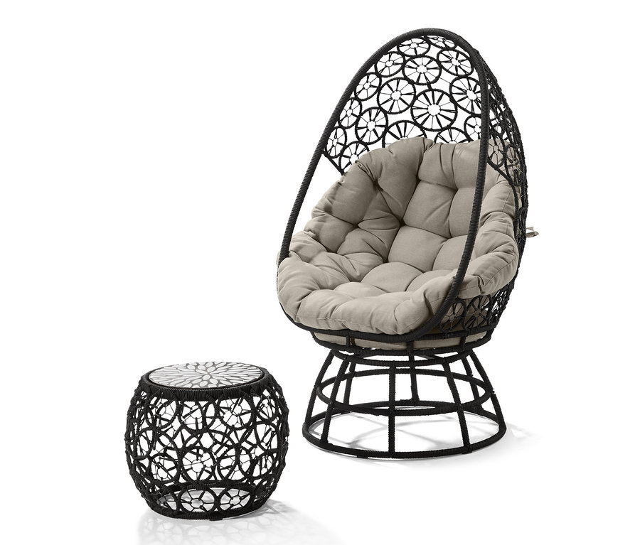 Ein schwarzer Drehsessel mit einem beigen Kissen und Beistelltisch.