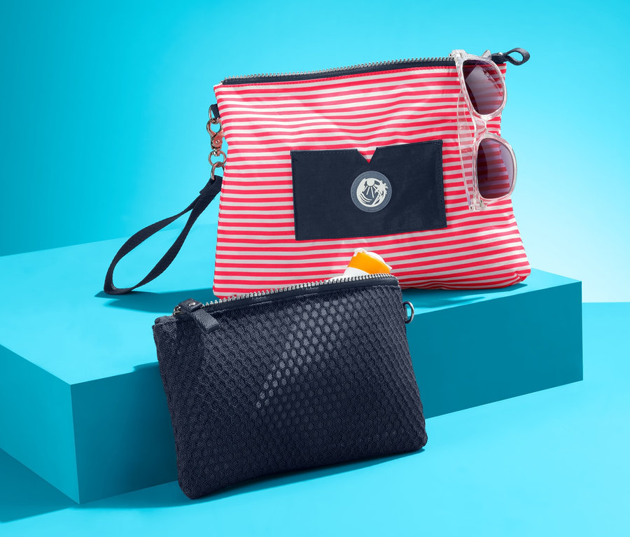 Zwei Taschen auf türkisfarbenem Hintergrund. Eine Tasche ist rot-weiss gestreift und hat eine Sonnenbrille. Die andere Tasche ist dunkelblau. Taschen-Set