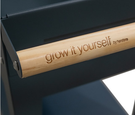 Detailansicht einer anthrazitfarbenen Kräuterfabrik von Herstera Garden mit Holzgriff und der Aufschrift "grow it yourself".