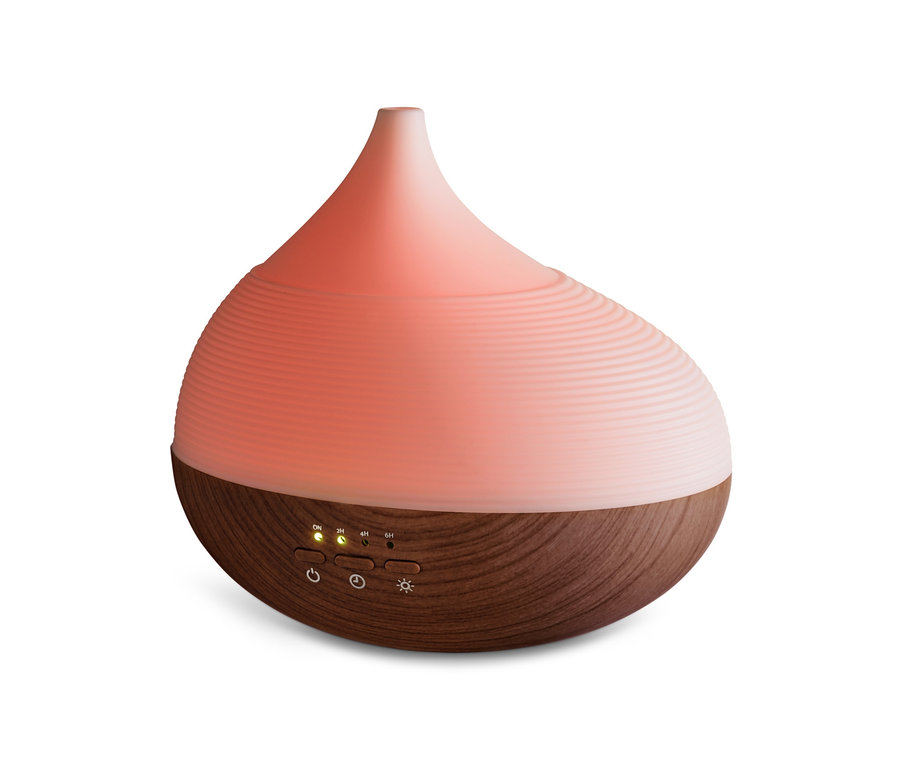 Nahaufnahme eines Aromadiffusors mit Wellness-Beleuchtung, der oben hellrosa und unten holzfarben ist.