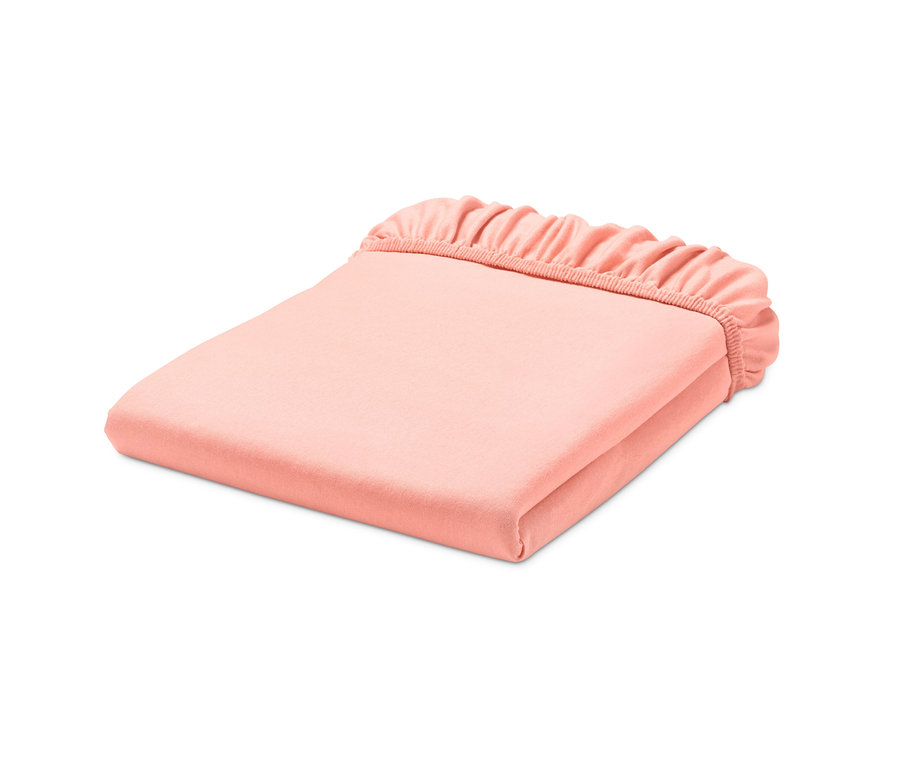 Ein gefaltetes, apricotfarbenes Jersey-Spannbettlaken.