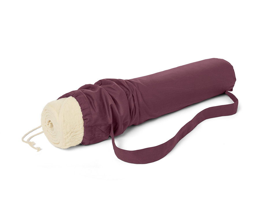 Eine zusammengerollte Schurwoll-Yogamatte in einer bordeauxfarbenen Tasche mit Riemen.