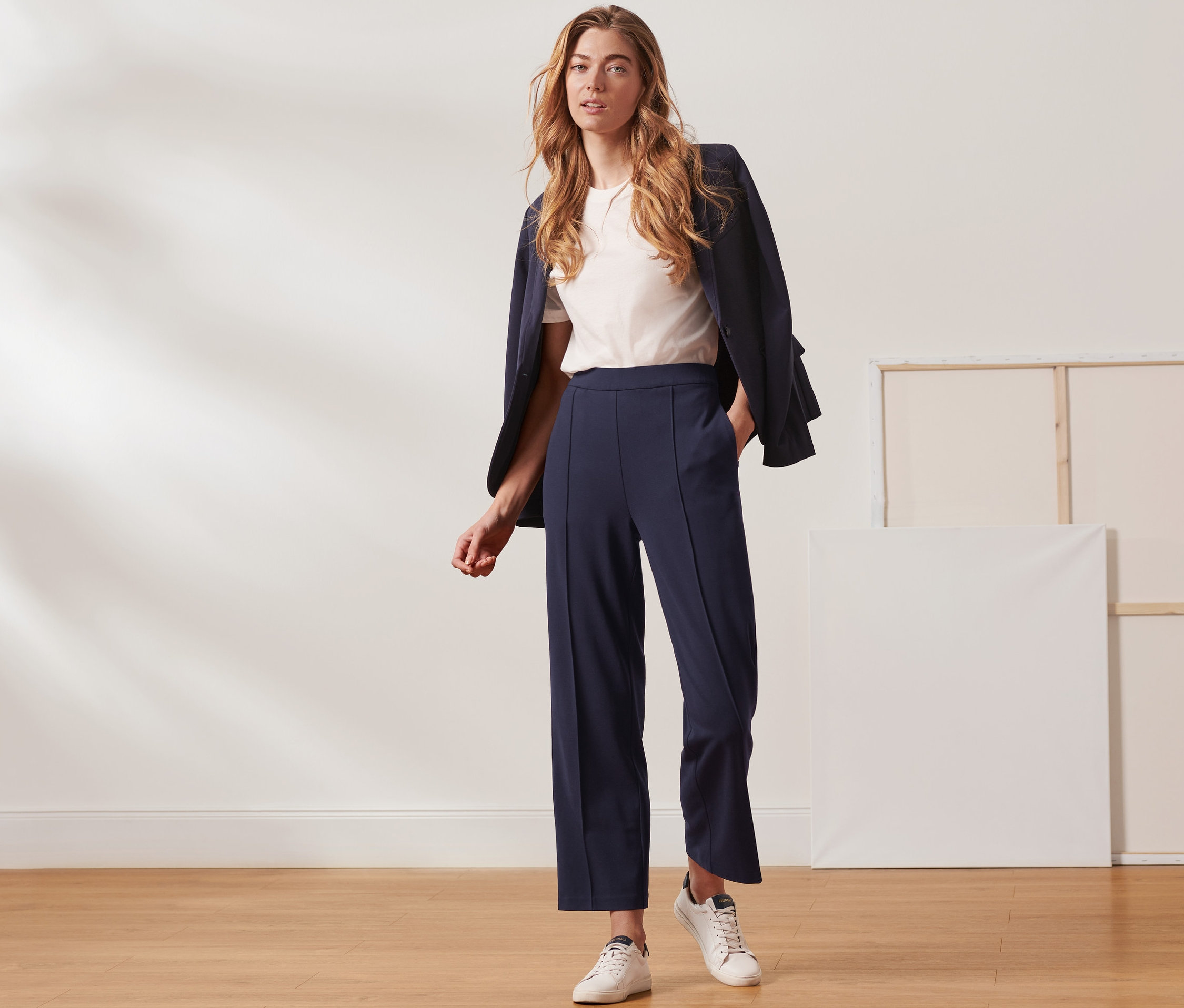Frau posiert im Studio und trägt eine dunkelblaue Jerseyhose mit Biese.