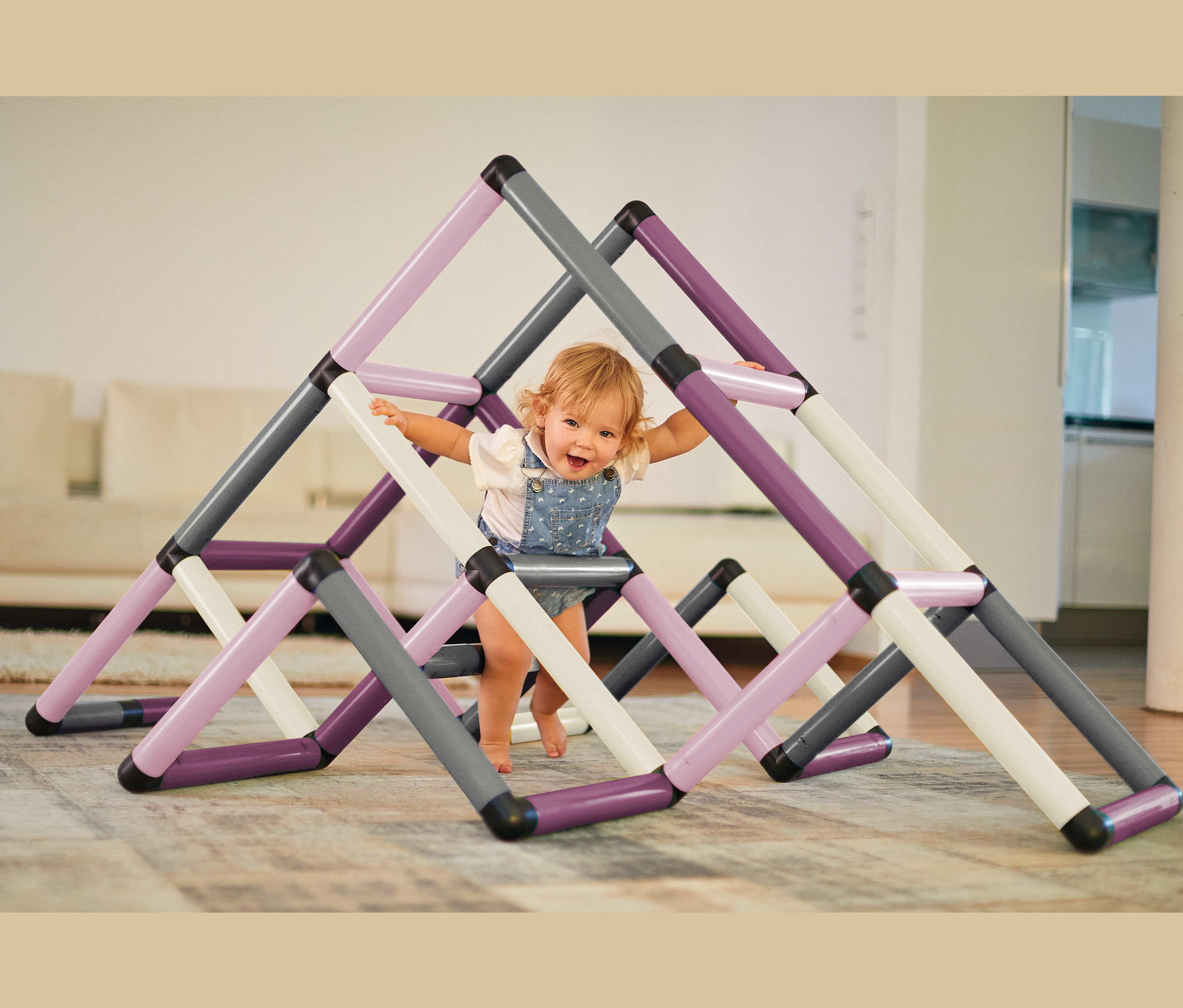 Kleinkind klettert auf Quadro-Home-ADVENTURE-Set Klettergerüst mit lila, grauen und weißen Rohren.