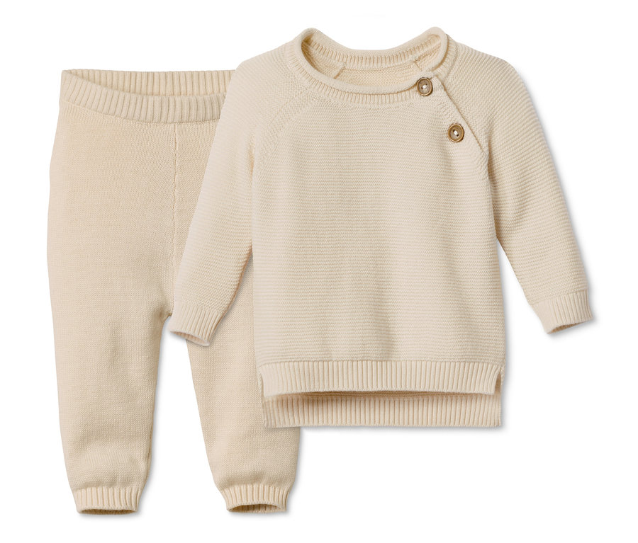 Baby Baumwoll-Strickkombi. Der Pullover hat Knöpfe am Hals, die Hose hat einen elastischen Bund.