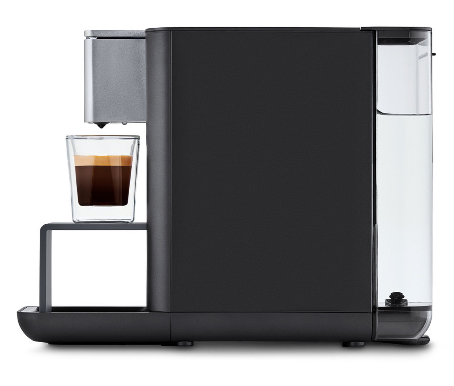 Qbo ESSENTIAL Dark Stone Kaffeemaschine mit einer Tasse Kaffee.