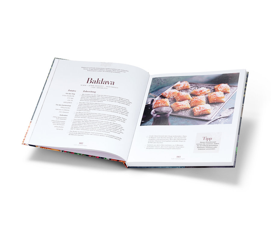 Aufgeschlagenes Kochbuch mit Baklava-Rezept und einem Foto von Baklava.