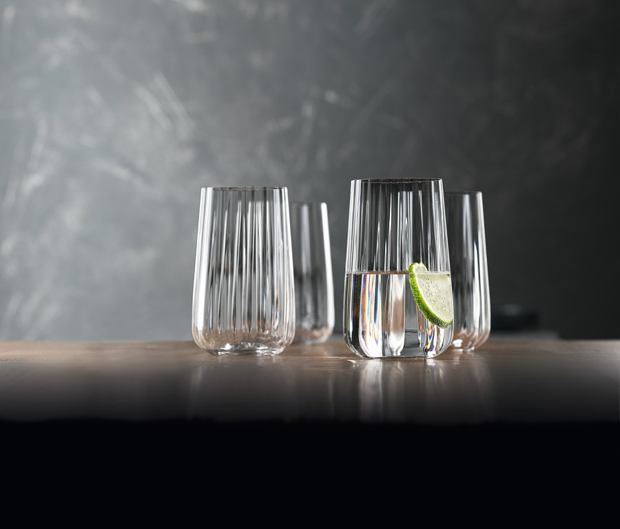Vier Spiegelau Longdrinkgläser »Lifestyle« aus einem 8er-Set stehen auf einem Tisch, eines davon mit einer Limettenscheibe.