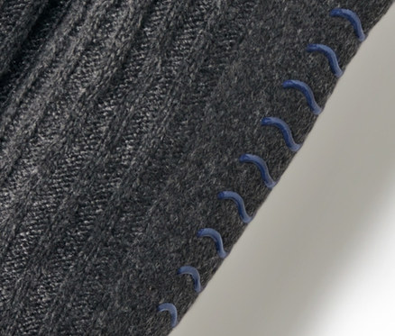 Detailaufnahme einer grauen Hausschuhsocke mit blauen Anti-Rutsch-Noppen.