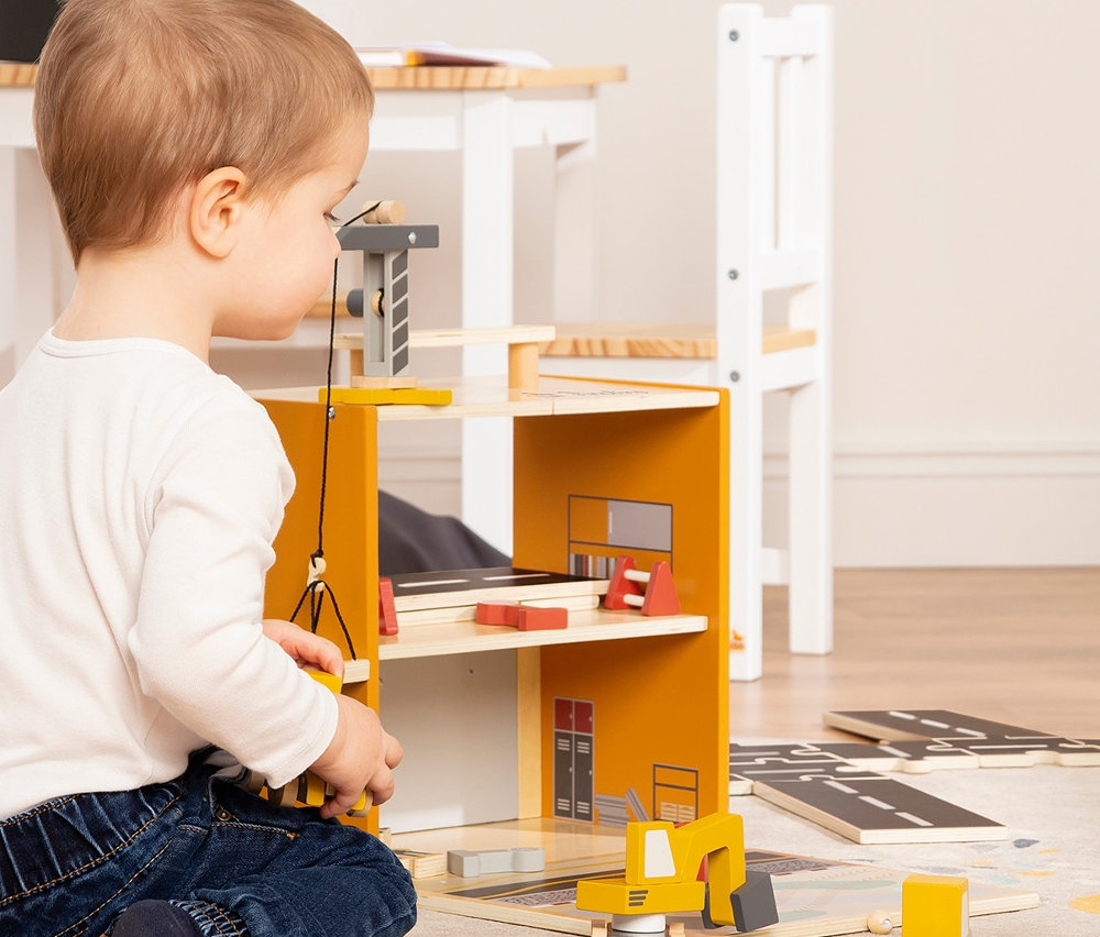 Junge spielt mit Pinolino Spielwelt »Baustelle Gustav« Holzspielzeug.