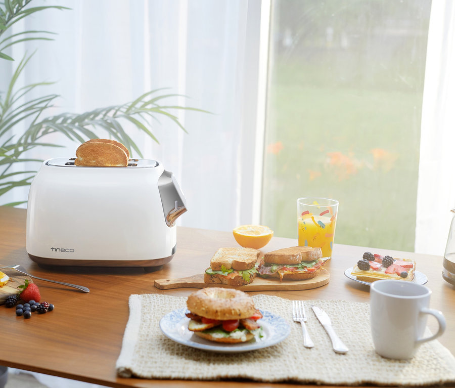 Zwei Toasts im Tineco Toaster »Toasty One« auf einem Tisch mit Essen.