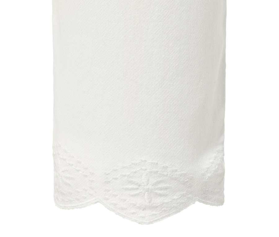 Detail einer weißen 7/8-Treggings mit Lochstickerei am Saum.