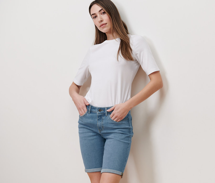 Eine Frau posiert in Bermuda Jeans – Fit »Lea« und einem weißen T-Shirt.