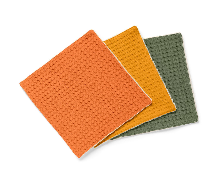 Drei saugstarke Spültücher in Orange, Gelb und Grün.