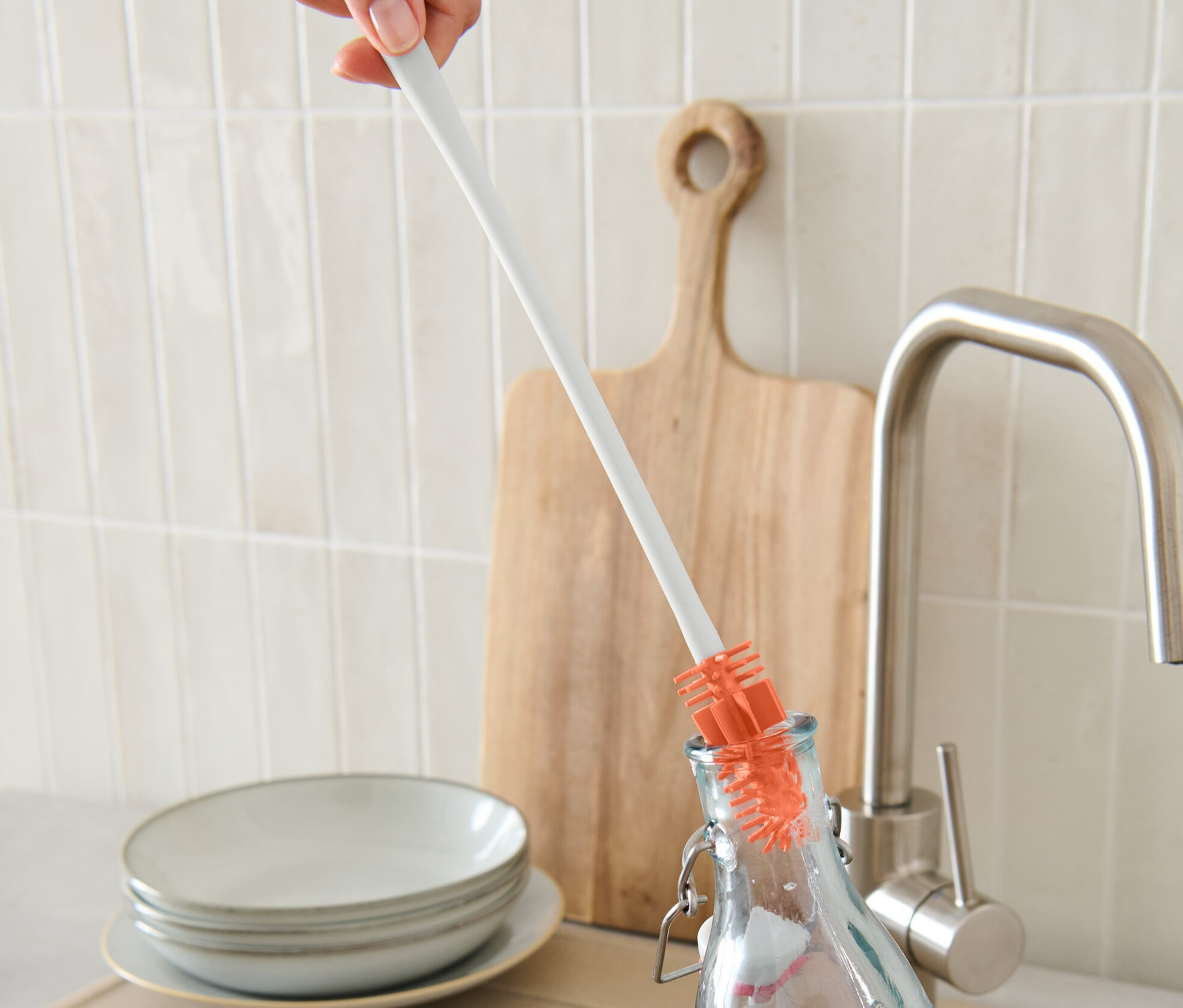 Eine Hand reinigt eine Flasche mit einer Flaschen-Reinigungsbürste.