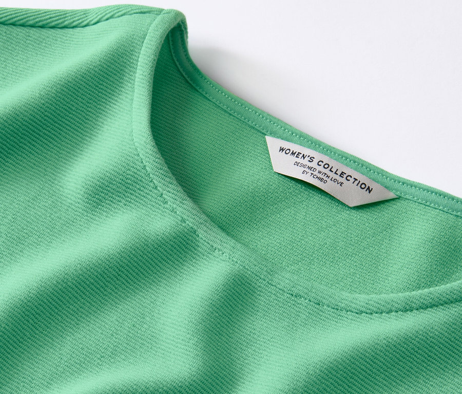 Detailansicht eines grünen Blusenshirts.