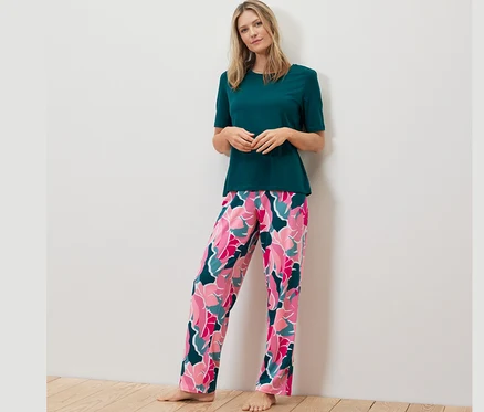 Frau trägt ein Pyjama-Set mit Blumenmuster.