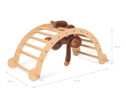 Ein brauner Plüschaffe liegt auf und hängt an einer hölzernen Pinolino Kletterbogen und Wippe.
