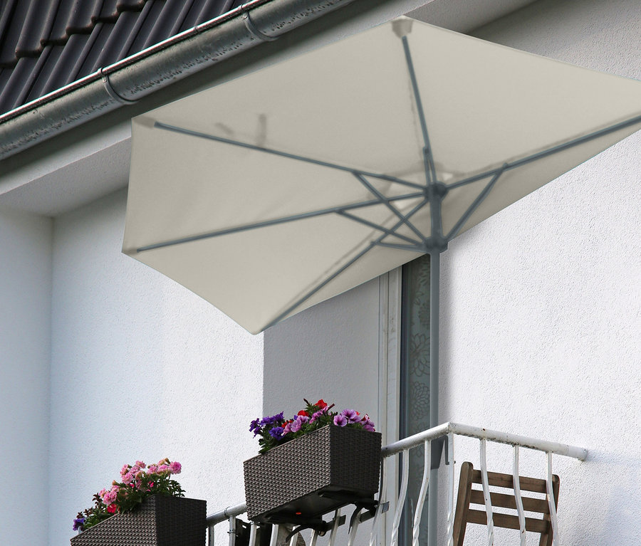 Balkon mit zwei Stühlen, Blumen in Pflanzkästen und einem halbrunden grauen Leco Balkon-Sonnenschirm.