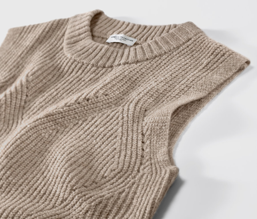 Detailaufnahme eines beige melierten Strick-Pullunders.