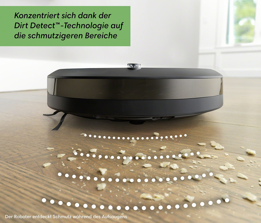 Schwarzer iRobot Saugroboter Roomba i1 auf Holzboden mit Schmutz.