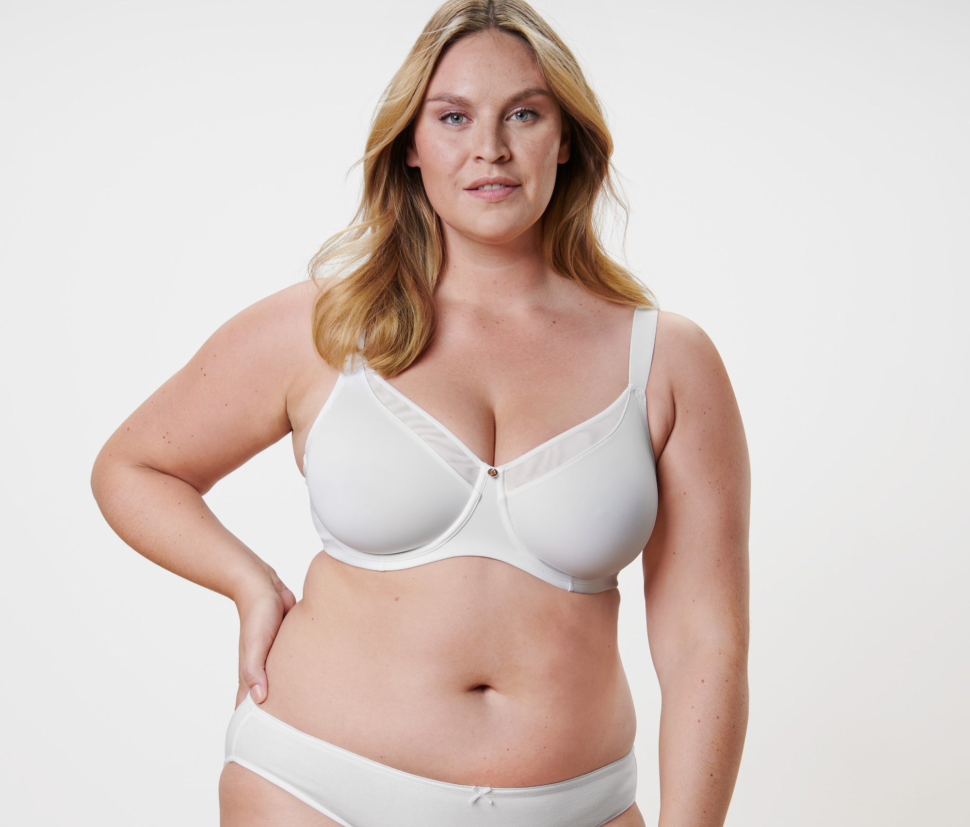 Blonde Frau posiert in weißem Minimizer-BH.