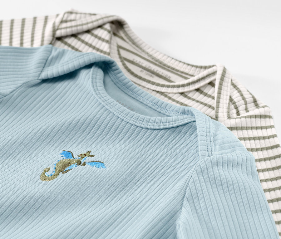 Zwei Baby-Langarmshirts mit Rippstruktur, hellblau mit Stickerei und grün-weiss gestreift.