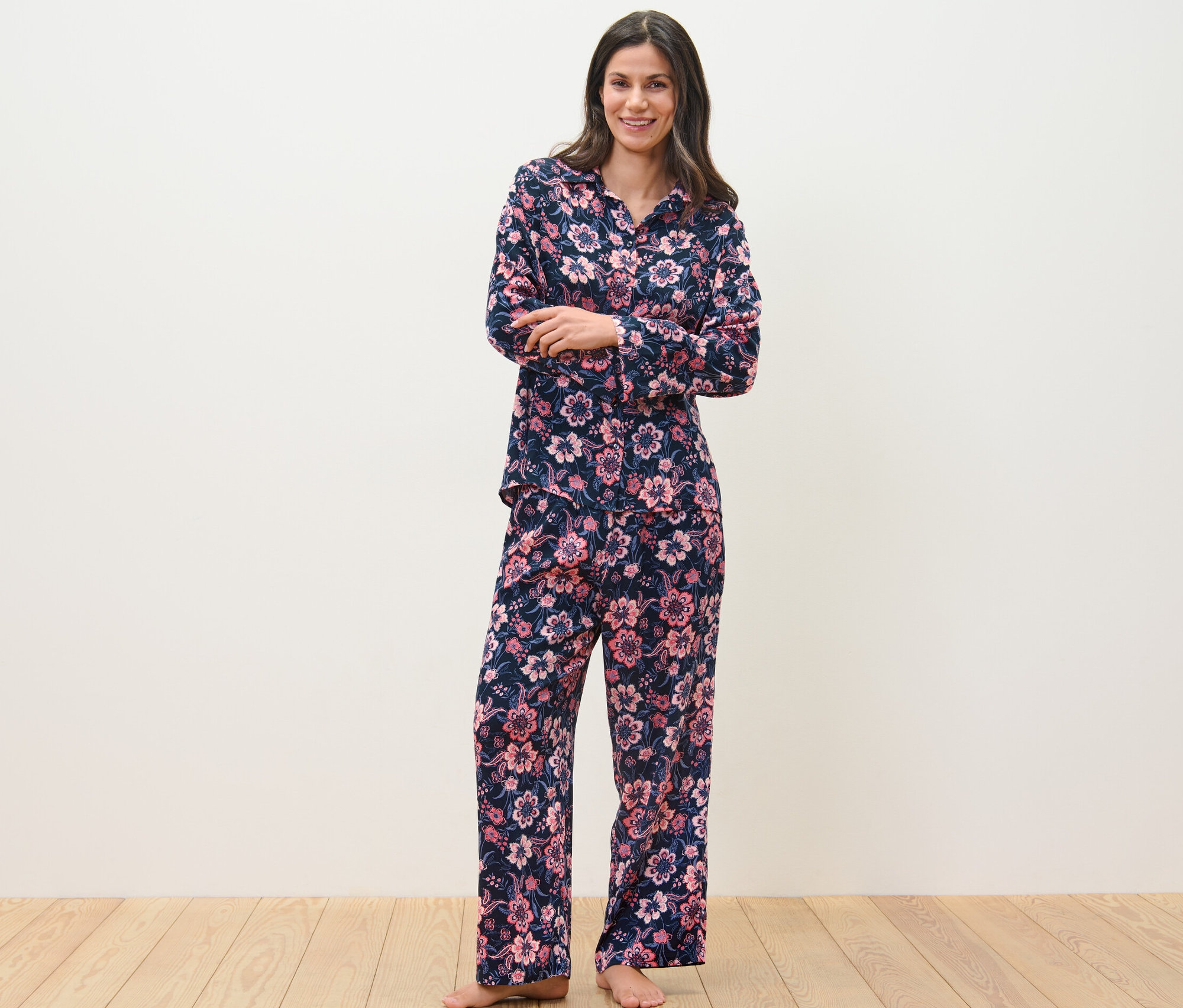 Eine Frau steht und trägt einen Web-Pyjama mit Blumenmuster.