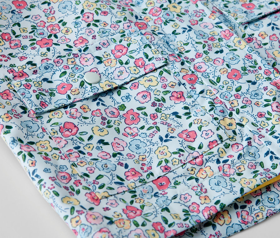 Detailaufnahme einer Kinder-Regenjacke mit Blumenmuster.