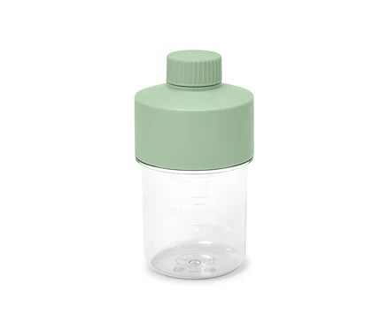 Transparente Dressingflasche mit mintgrünem Deckel.