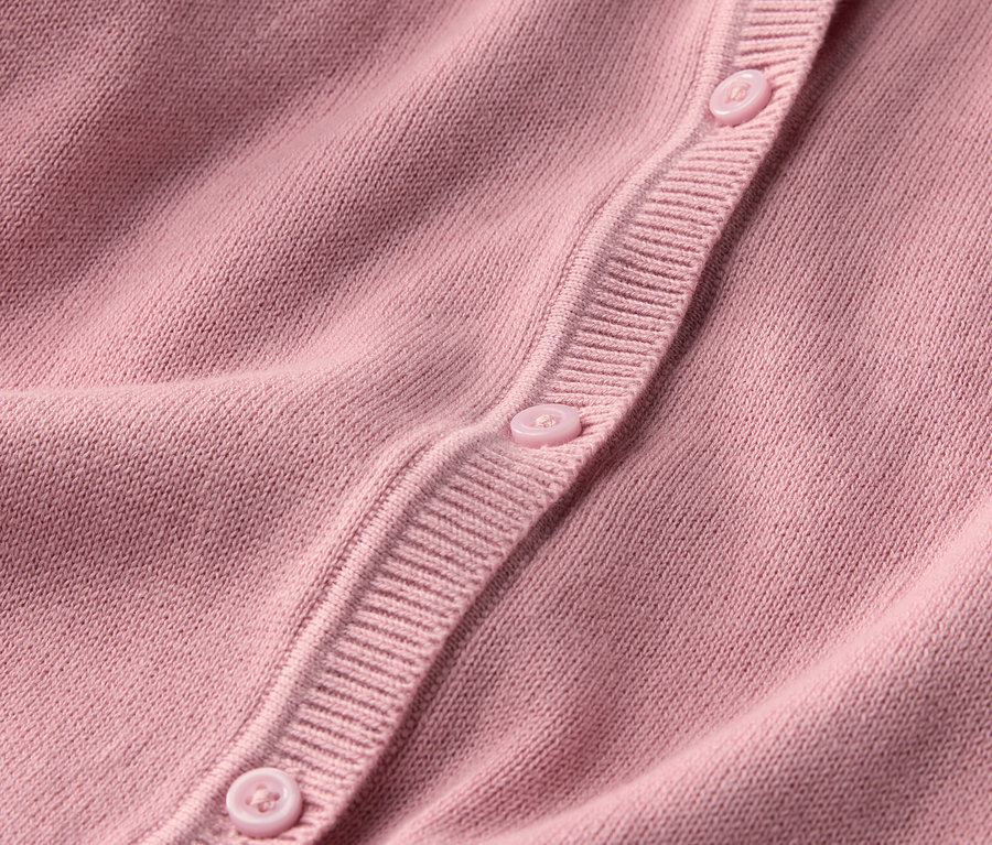 Detailansicht einer Kinder-Strickjacke mit Knöpfen.